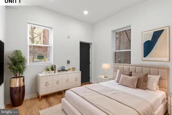 a bedroom with a large bed and a potted plant
