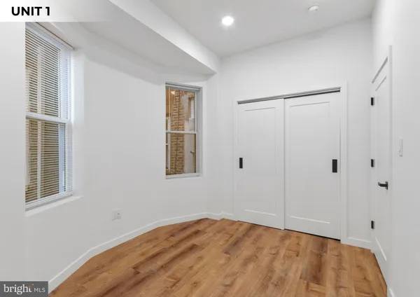 a view of an empty room with window and closet