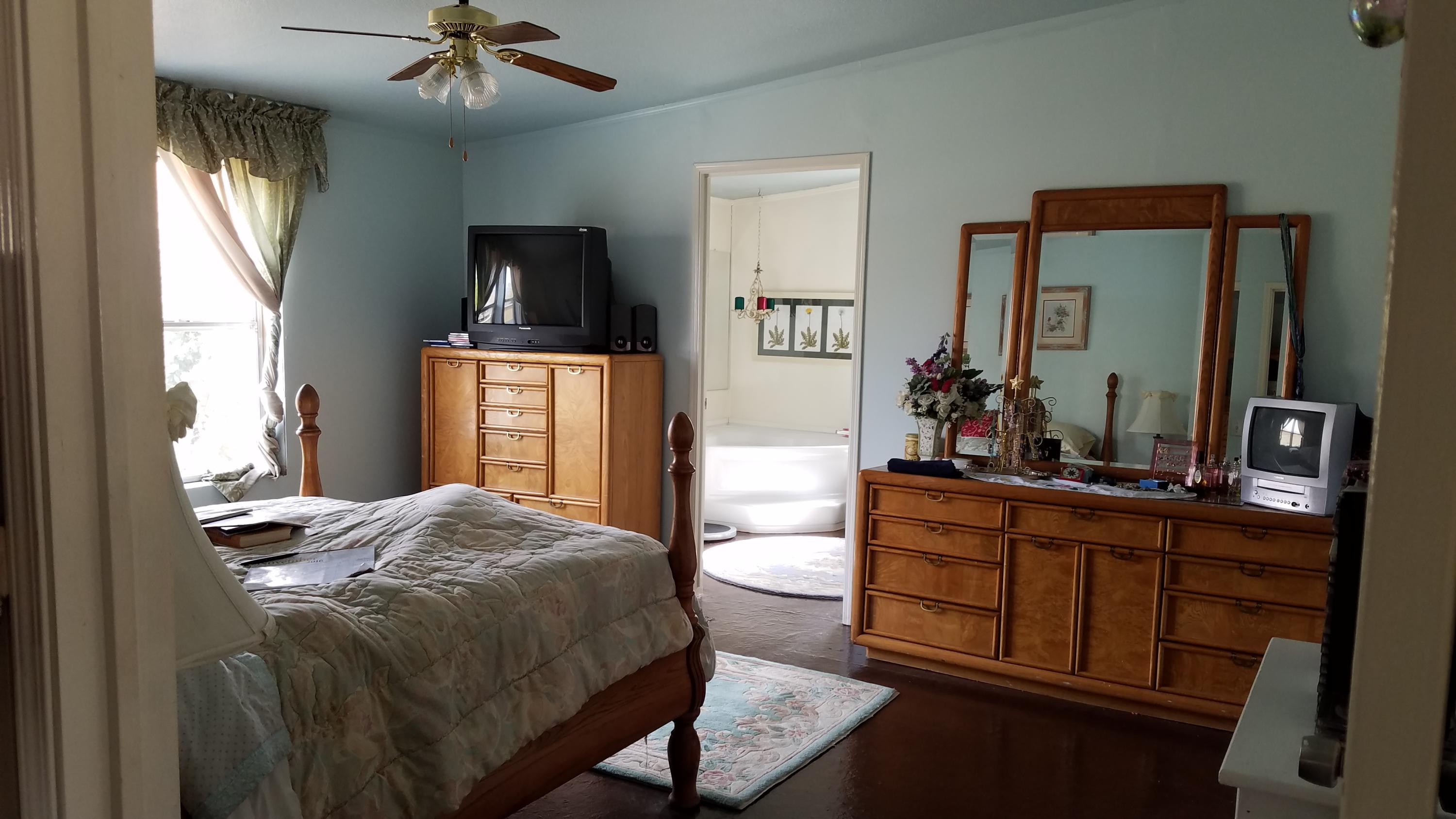 17215 Tehachapi Willow Springs Road Tehachapi, CA 93561 - Photo 5 of 45 a bedroom with a bed and a mirror on dresser