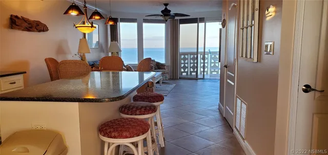 a dining room with furniture and a floor to ceiling window