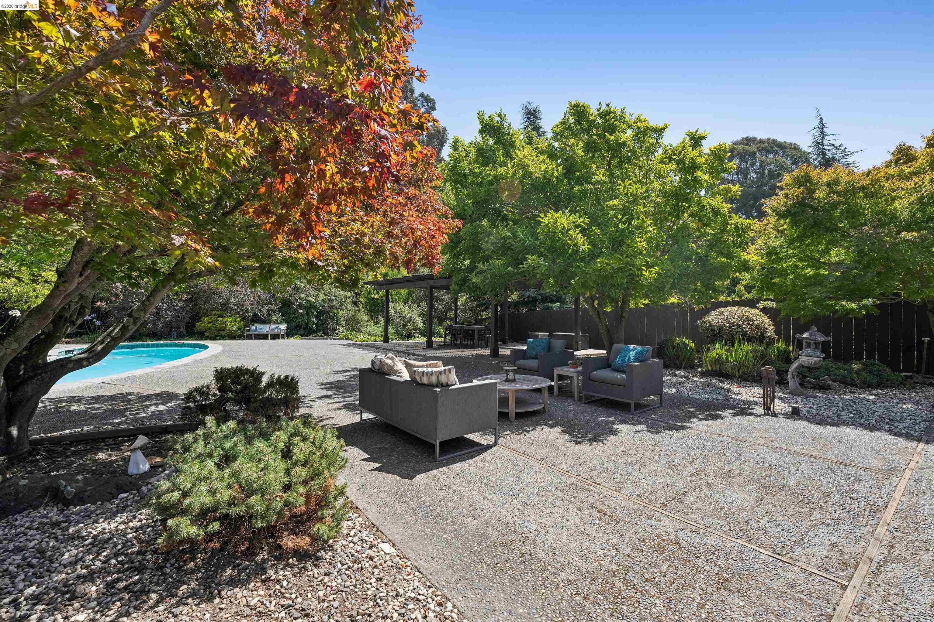 7 Jo Lin Court El Sobrante, CA 94803 - Photo 83 of 99 Expansive concrete patio area with a distinct pool surround and mature trees providing natural canopy