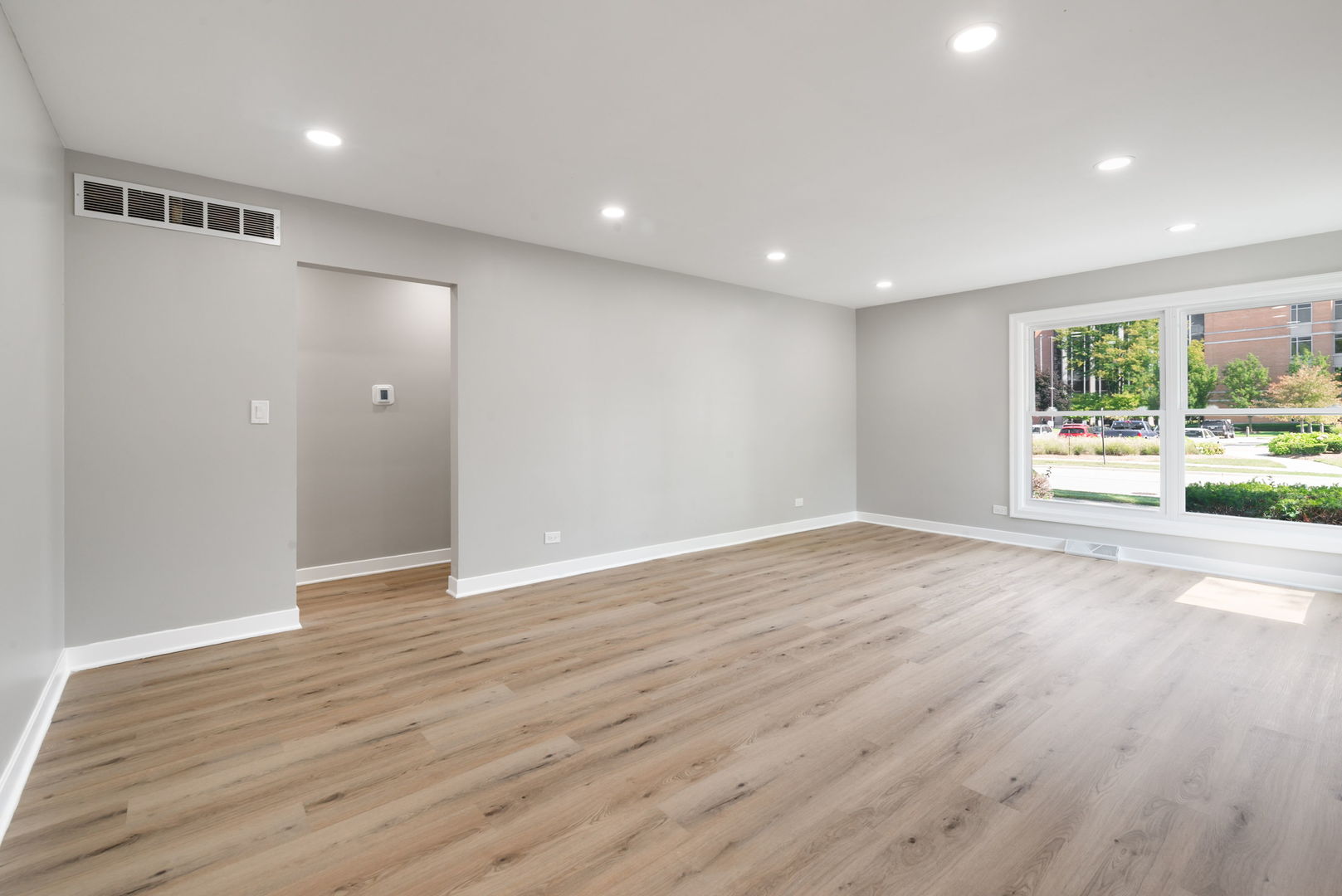 92 North Airlite Street Elgin, IL 60123 - Photo 4 of 25 an empty room with wooden floor and windows