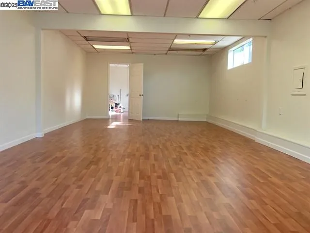 a view of a hallway with wooden floor and a bathroom