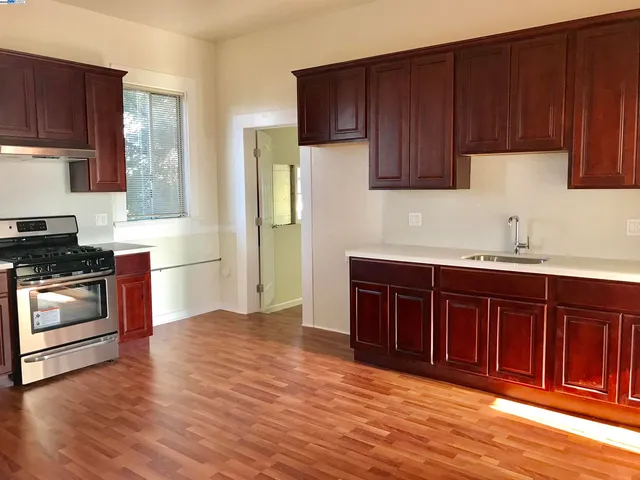 a kitchen with granite countertop wooden floors and stainless steel appliances