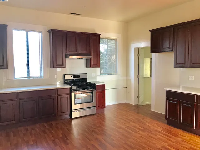 a kitchen with granite countertop wooden floors and stainless steel appliances