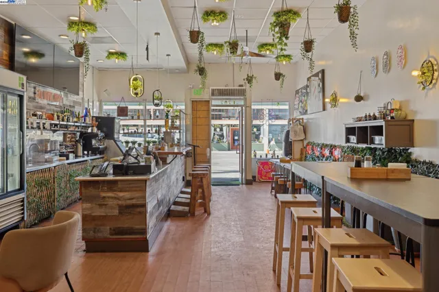 a room with stainless steel appliances kitchen island granite countertop lots of clutter