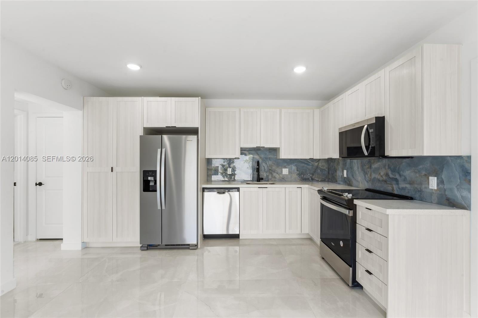14530 Southwest 261st Terrace, Unit 1 Homestead, FL 33032 - Photo 4 of 17 a kitchen with stainless steel appliances granite countertop a refrigerator stove a sink and microwave