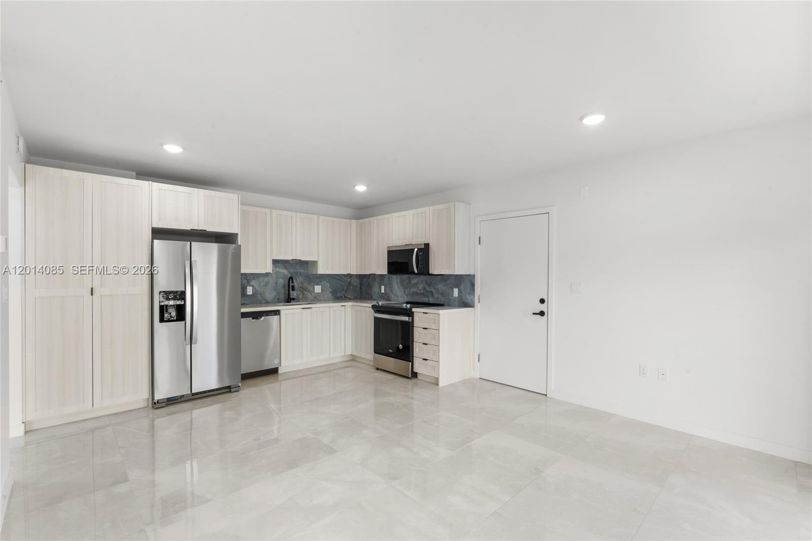 14530 Southwest 261st Terrace, Unit 1 Homestead, FL 33032 - Photo 5 of 17 a kitchen with white cabinets and stainless steel appliances