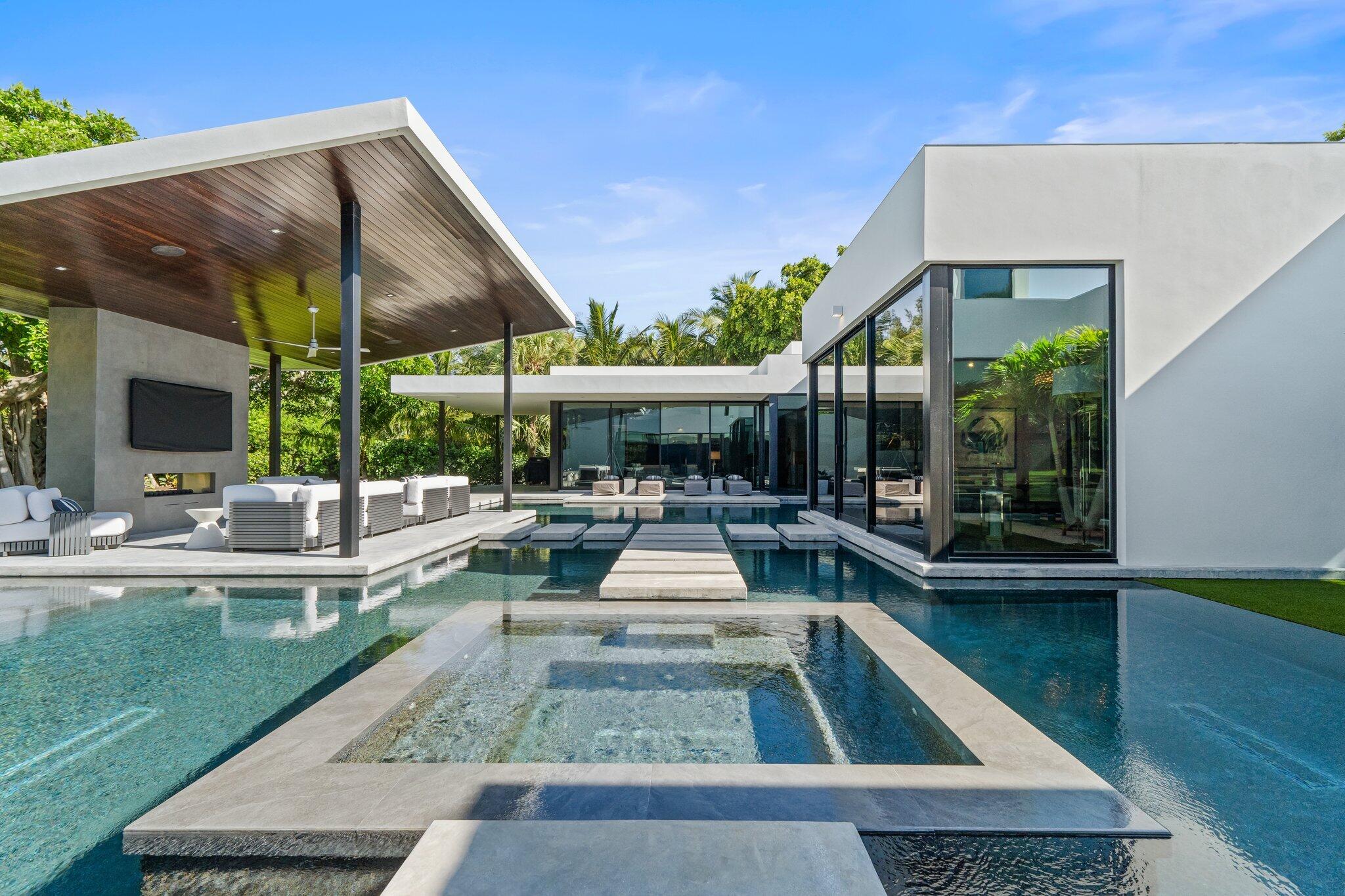 12 North Beach Road Jupiter Island, FL 33455 - Photo 32 of 95 a view of a patio with table and chairs potted plants with floor to ceiling window