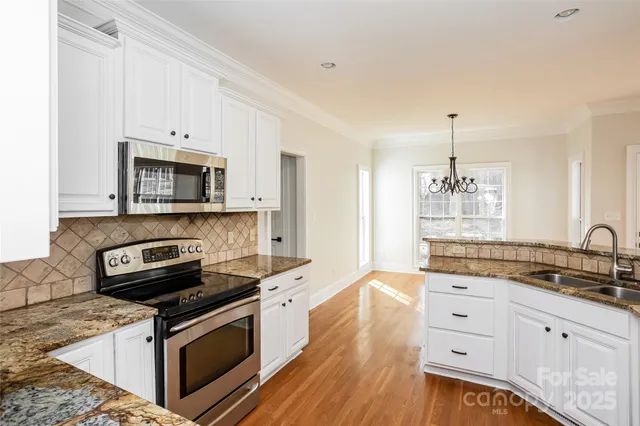 a kitchen with granite countertop a stove sink and cabinets