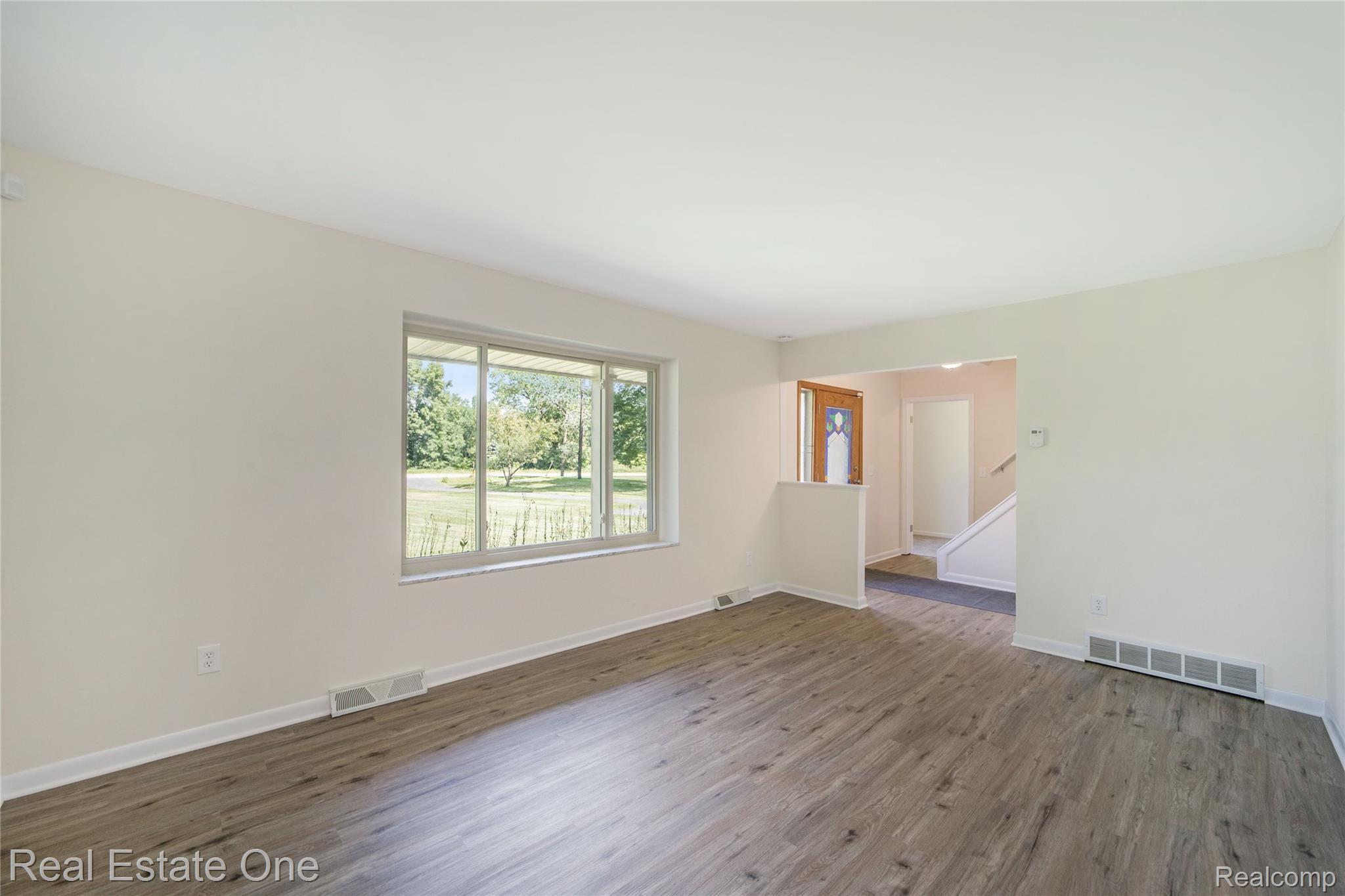 9069 Clark Road Clarkston, MI 48346 - Photo 19 of 51 Light filled living room. Guest bedroom or office in the background.