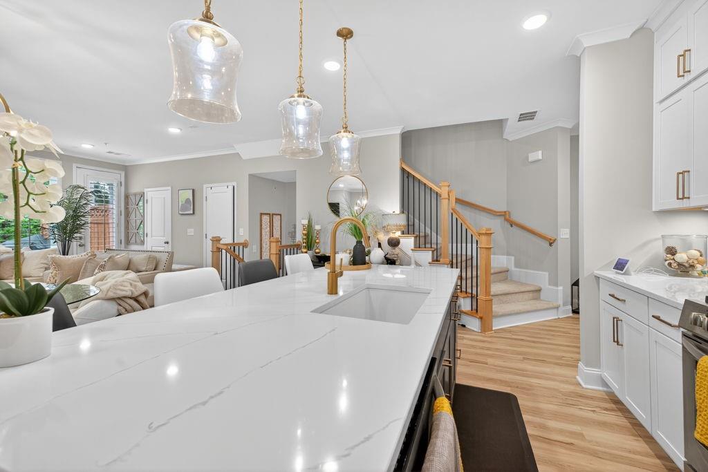 425 Retreat Lane Canton, GA 30114 - Photo 11 of 55 a large white kitchen with a large island oven a stove and a chandelier