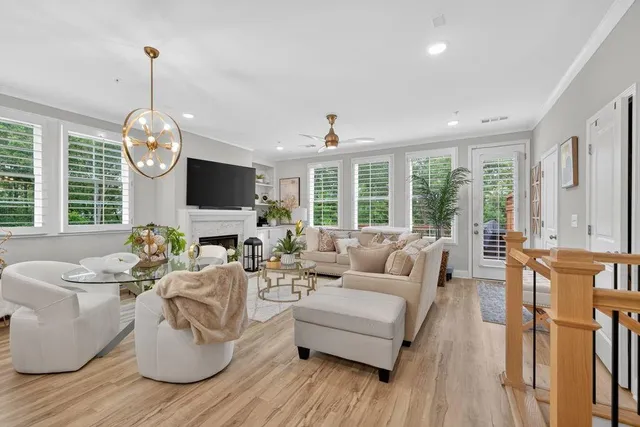 a living room with furniture a fireplace and a chandelier