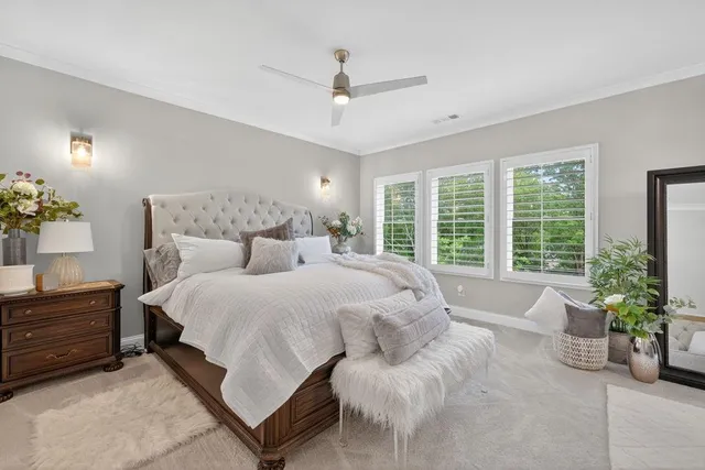 a bedroom with a large bed couch and a large window