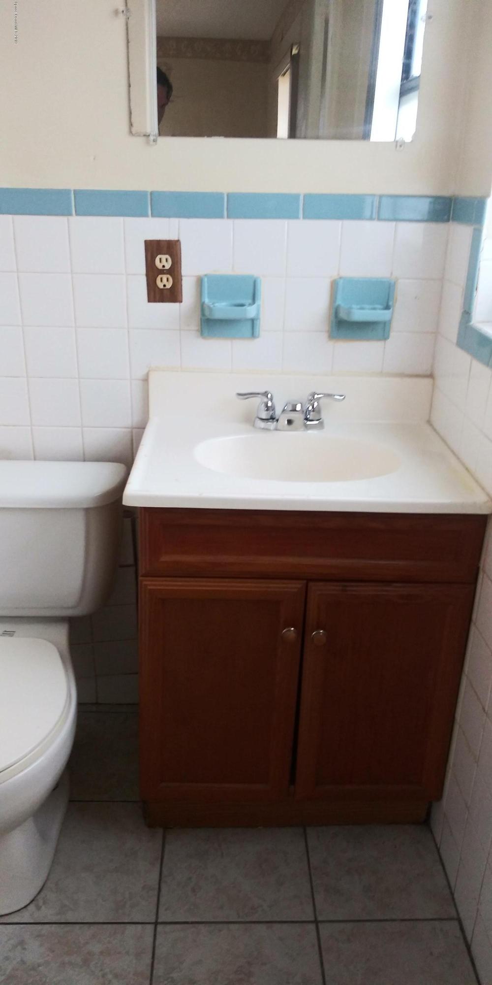 2465 Dolphin Road Titusville, FL 32780 - Photo 16 of 40 a bathroom with a sink toilet and mirror