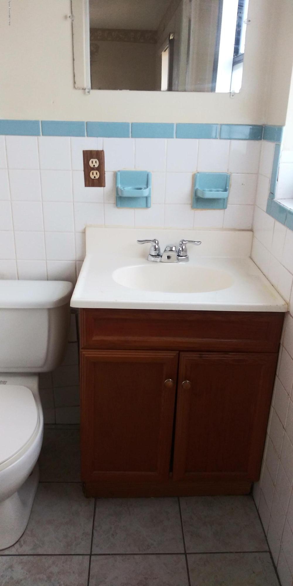 2465 Dolphin Road Titusville, FL 32780 - Photo 20 of 40 a bathroom with a sink a toilet and mirror
