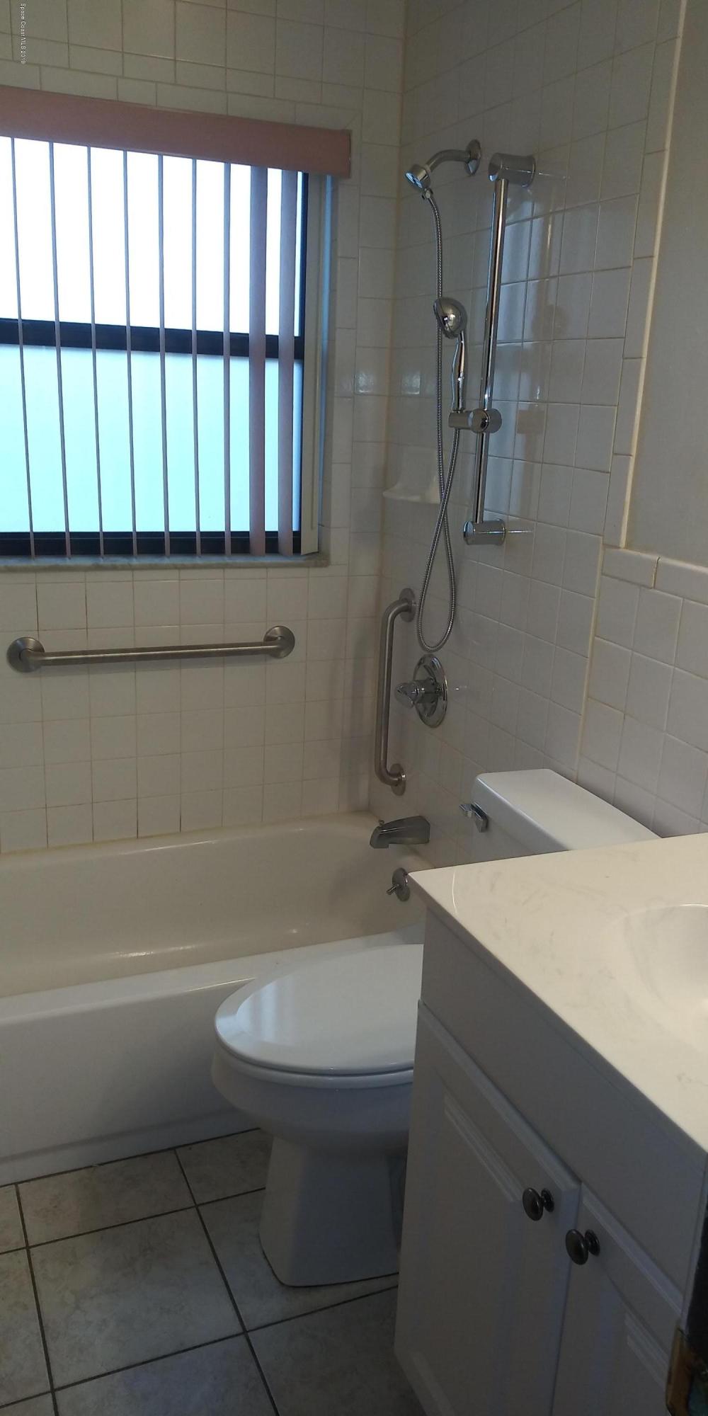 2465 Dolphin Road Titusville, FL 32780 - Photo 24 of 40 a bathroom with a granite countertop toilet a sink and a bathtub