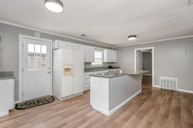 a view of kitchen with refrigerator stove and wooden floor