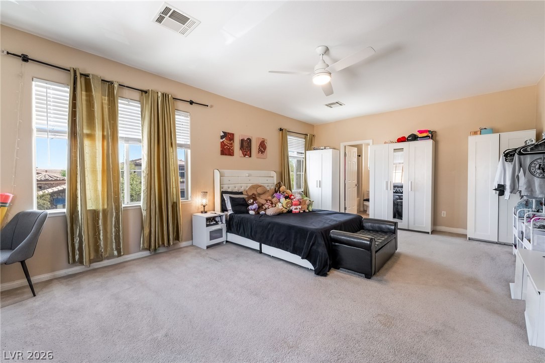 8358 Nelson Ridge Lane Las Vegas, NV 89178 - Photo 27 of 43 Well-lit sleeping quarters with a ceiling fan, plush carpet, and ample natural light from multiple windows.