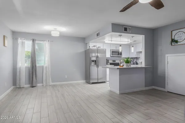 a view of a kitchen with refrigerator and wooden floor
