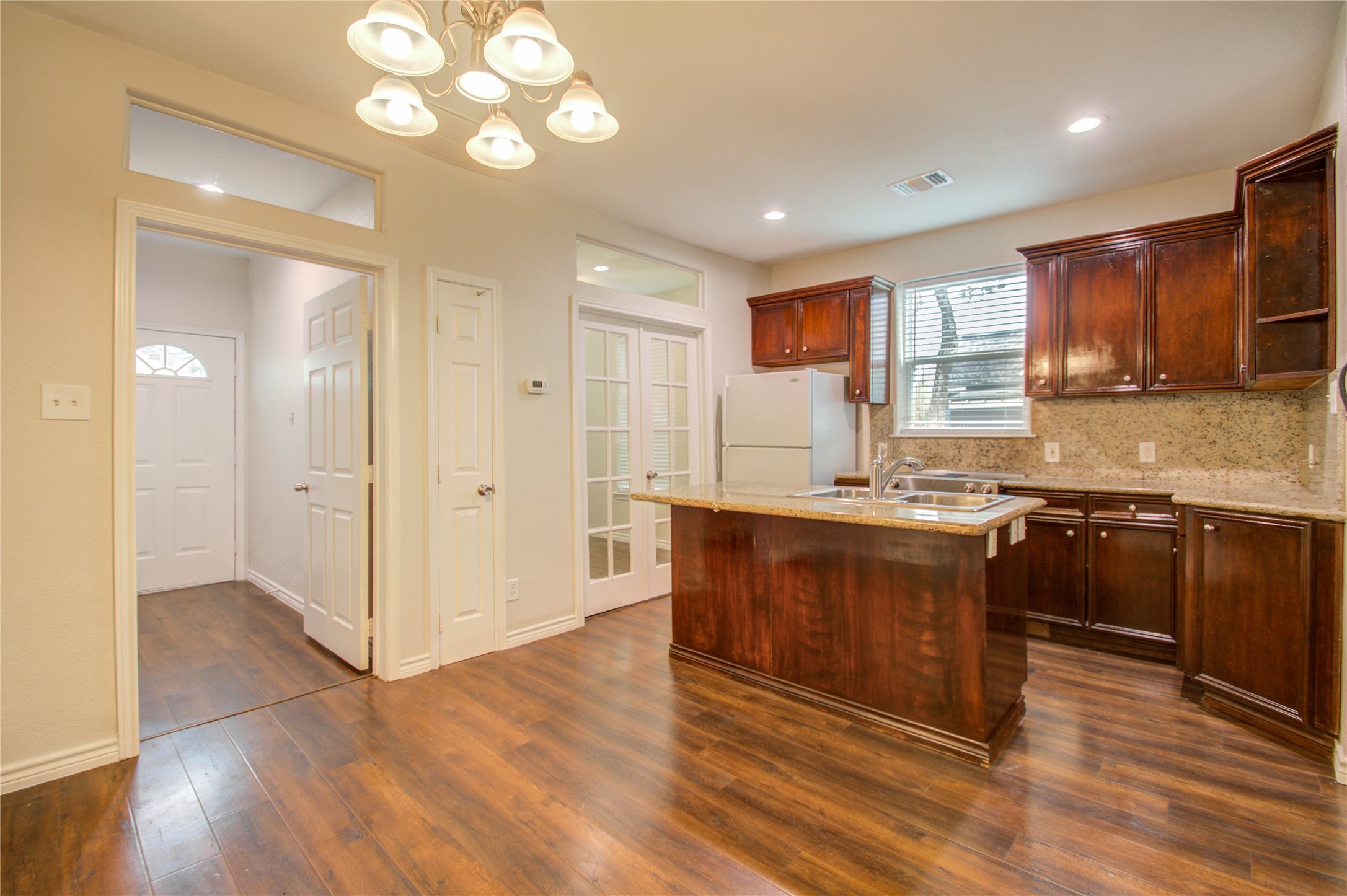 2119 Kane Street Houston, TX 77007 - Photo 19 of 29 a large kitchen with granite countertop a stove top oven a sink and dishwasher with wooden floor