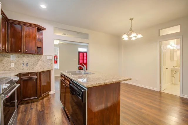 a kitchen with granite countertop a sink cabinets and wooden floor