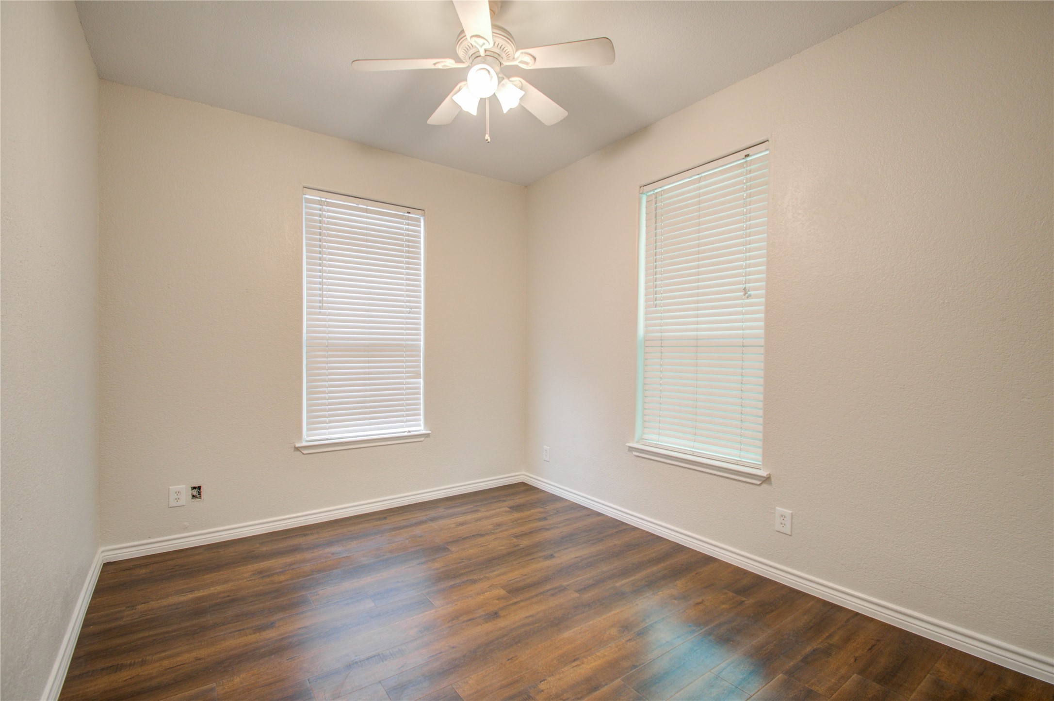 2119 Kane Street Houston, TX 77007 - Photo 10 of 29 an empty room with wooden floor ceiling fan and windows