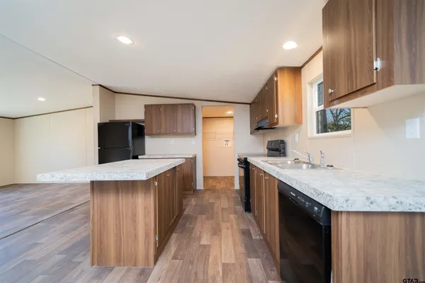 a kitchen with a stove a sink a refrigerator and a microwave