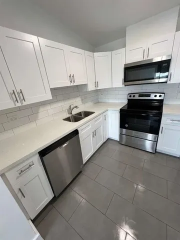 a kitchen with stainless steel appliances a stove a sink and a microwave