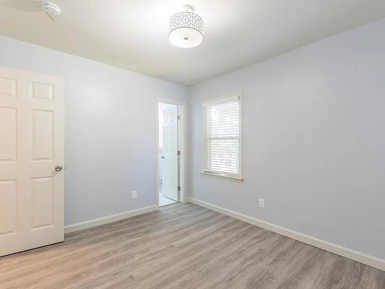 2077 Green Forrest Drive Decatur, GA 30032 - Photo 11 of 21 an empty room with wooden floor and windows