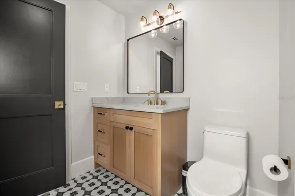a bathroom with a granite countertop sink mirror and toilet