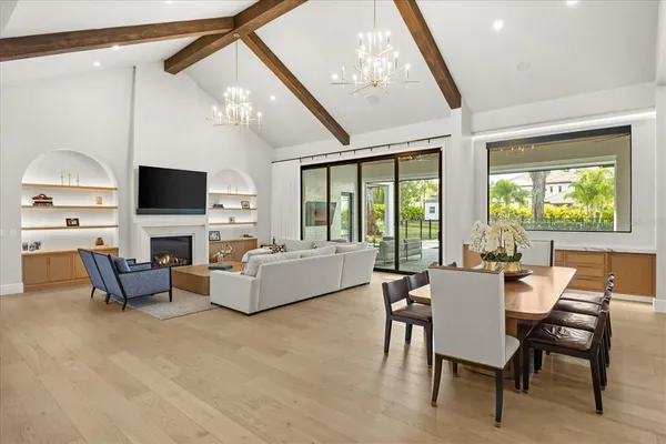 a kitchen with a dining table chairs refrigerator and microwave