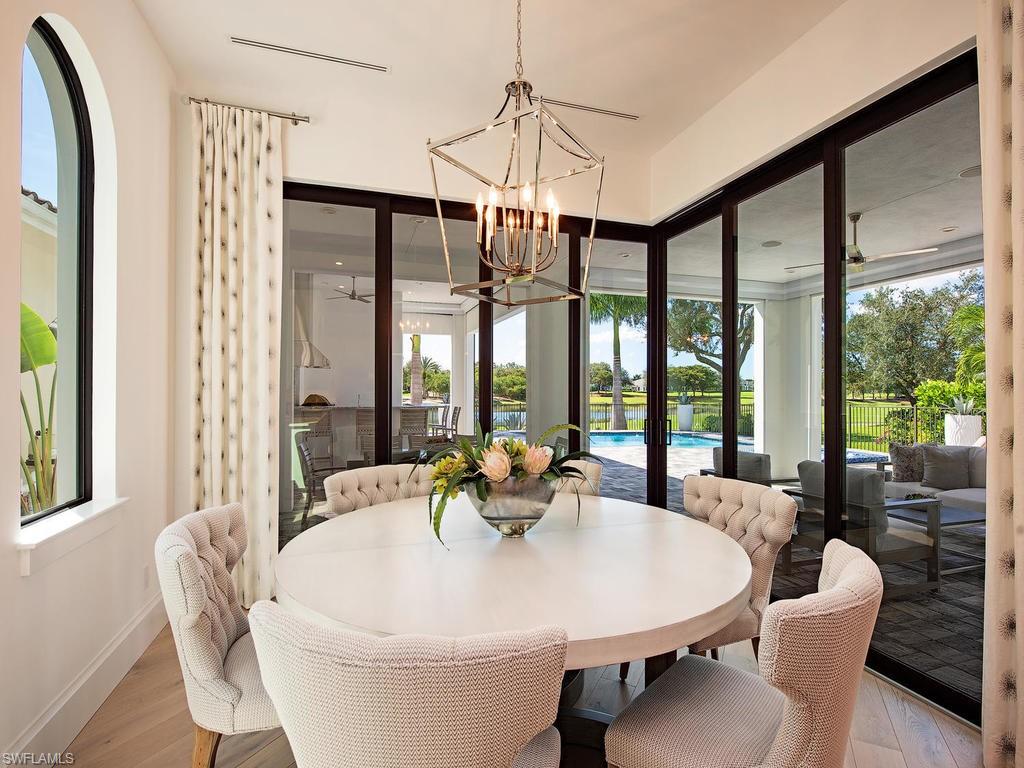 16868 Brightling Way Naples, FL 34110 - Photo 11 of 35 a view of a dining room with furniture large windows and wooden floor
