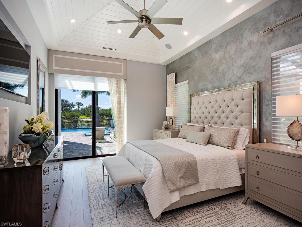 16868 Brightling Way Naples, FL 34110 - Photo 15 of 35 a bedroom with a large bed and a chandelier