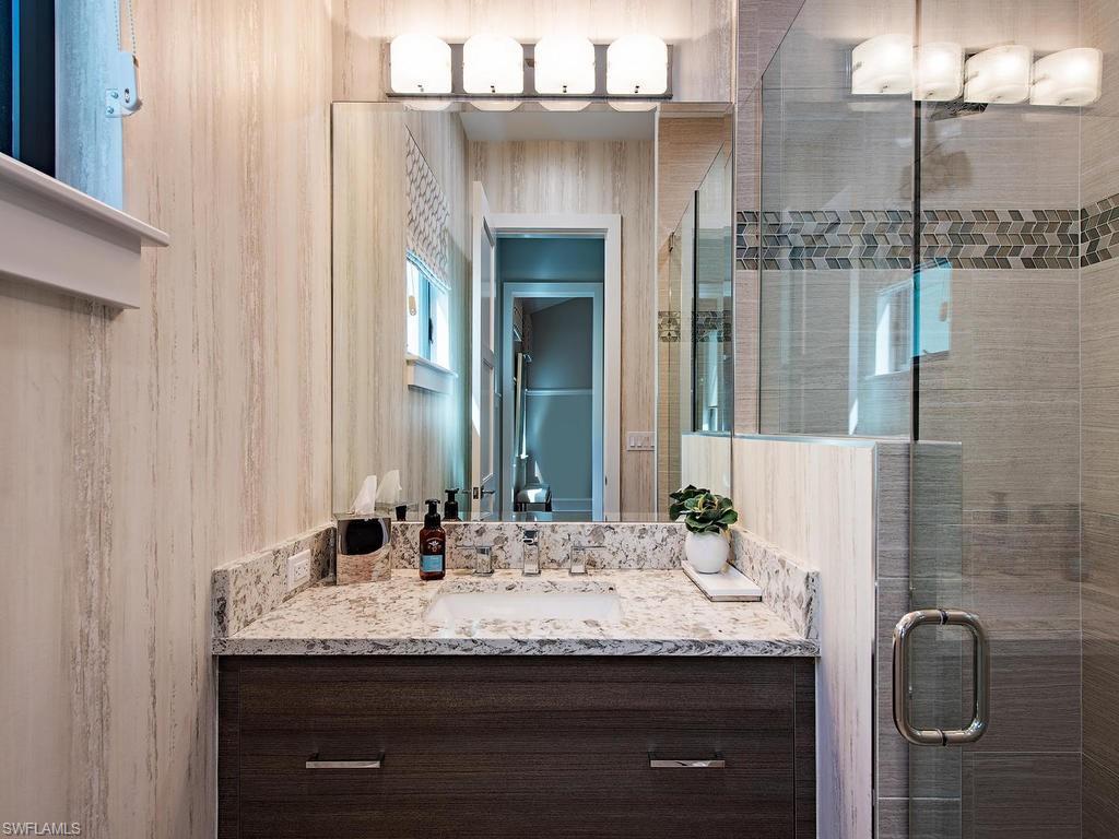 16868 Brightling Way Naples, FL 34110 - Photo 19 of 35 a bathroom with a granite countertop sink and a mirror