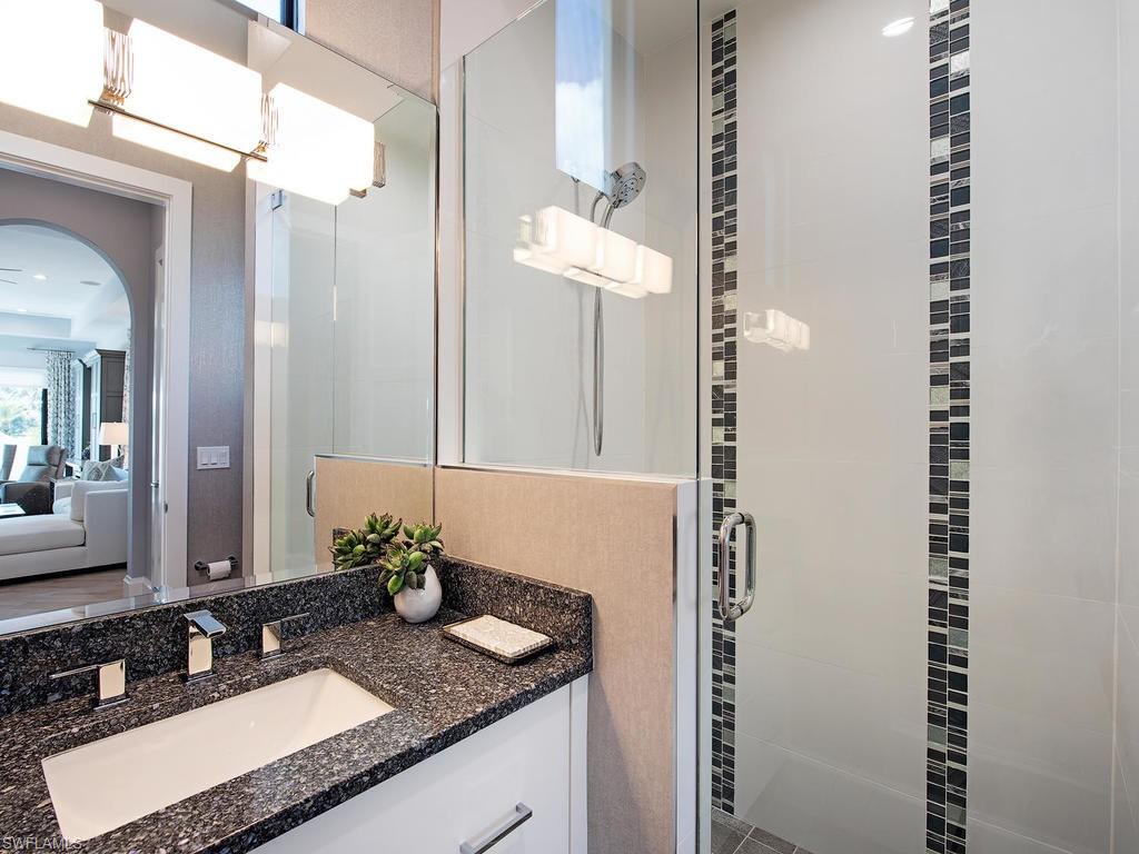 16868 Brightling Way Naples, FL 34110 - Photo 23 of 35 a bathroom with a granite countertop sink and a mirror