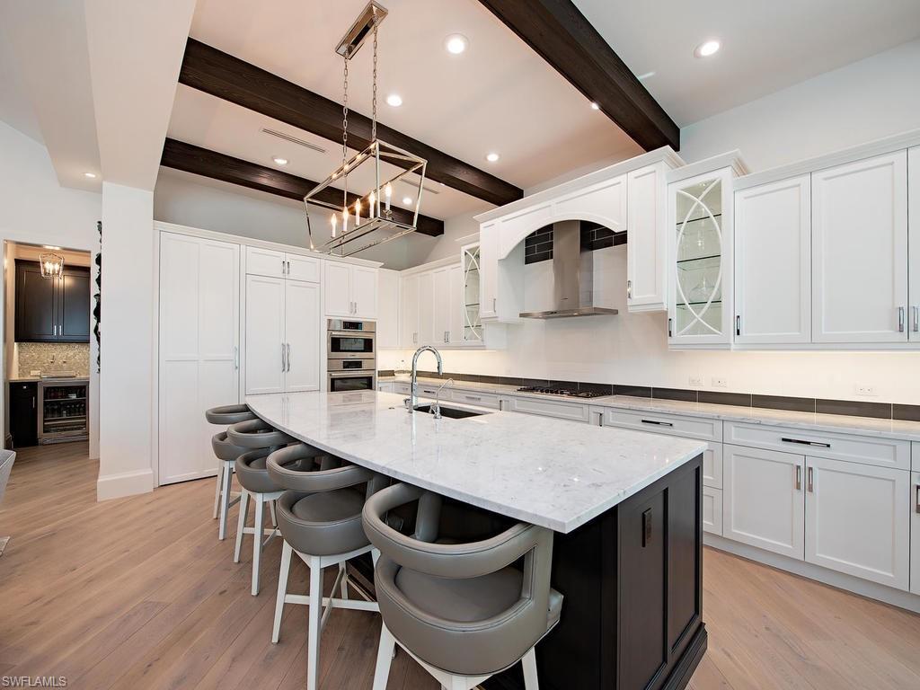 16868 Brightling Way Naples, FL 34110 - Photo 10 of 35 a kitchen with a table chairs sink and cabinets