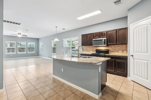 a kitchen with stainless steel appliances granite countertop a stove top oven a sink a counter top space and cabinets