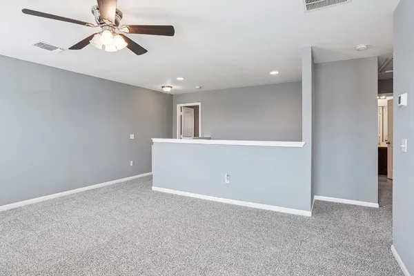 en empty room with ceiling fan and window