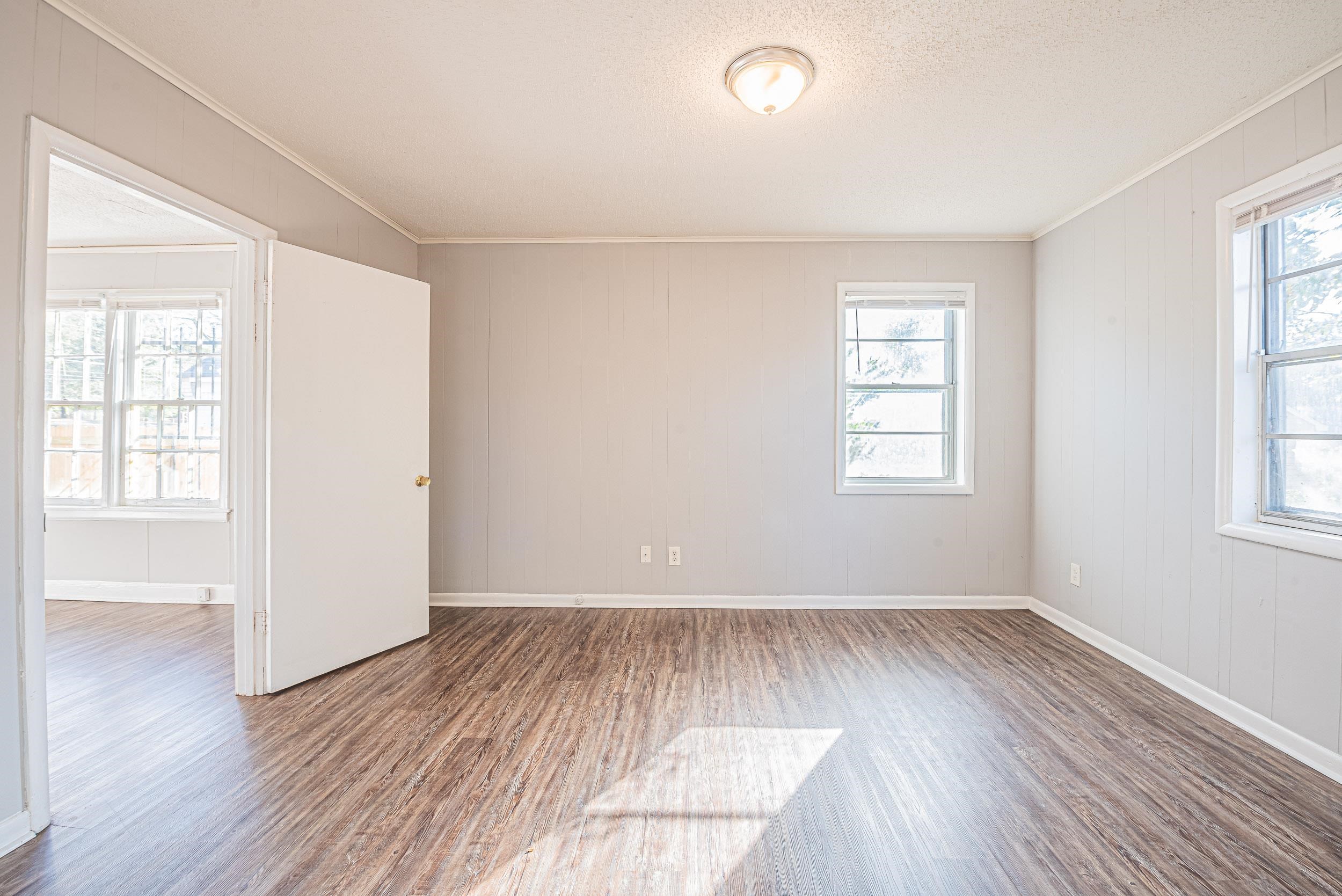1109 Getwell Road Memphis, TN 38111 - Photo 16 of 22 an empty room with wooden floor and windows