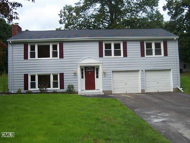 a view of a house with a yard and a large tree