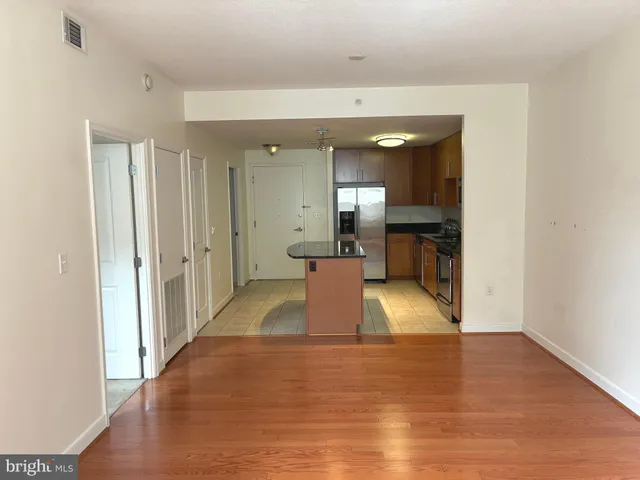 a view of a hallway with wooden floor and a bathroom