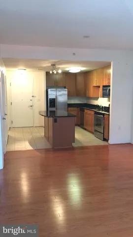 a kitchen with stainless steel appliances wooden floor and a sink