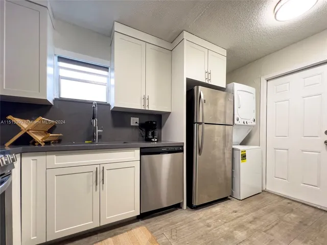 a kitchen with stainless steel appliances granite countertop a refrigerator sink and cabinets