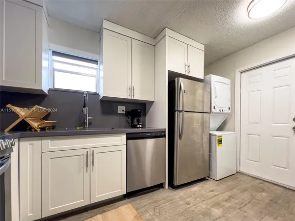 a kitchen with stainless steel appliances granite countertop a refrigerator sink and cabinets