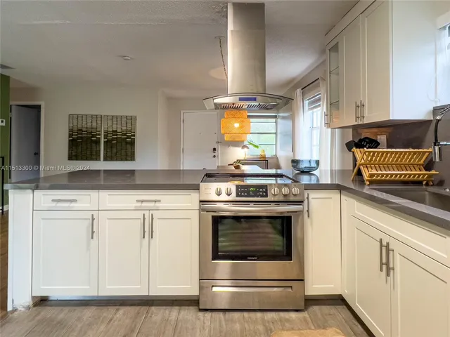 a kitchen with stainless steel appliances granite countertop a stove and white cabinets