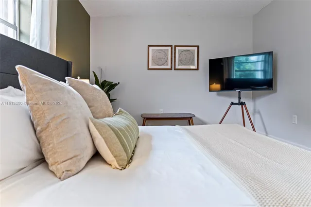 a bedroom with a bed and a flat screen tv