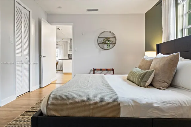 a bedroom with a bed and painting on the wall