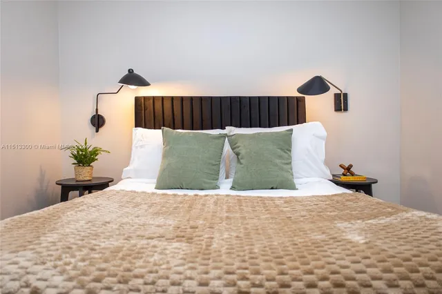 a bedroom with a bed and a potted plant