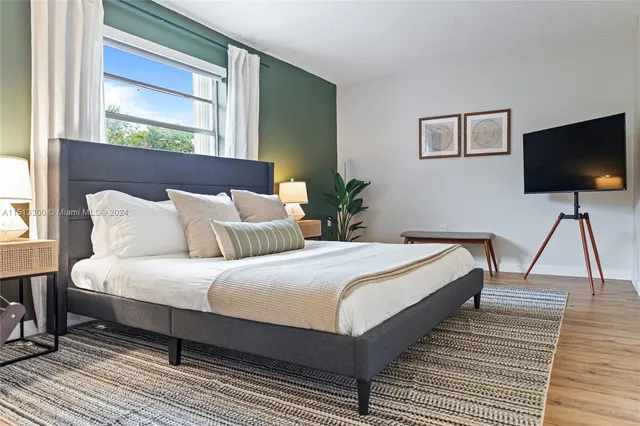 a bedroom with bed and a flat screen tv